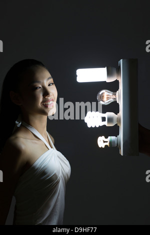 junge Frau mit Glühbirnen Stockfoto