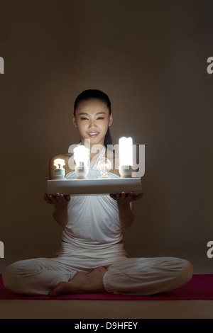 junge Frau mit Glühbirnen Stockfoto