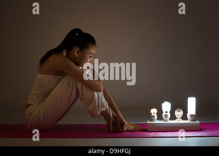 junge Frau mit Glühbirnen Stockfoto