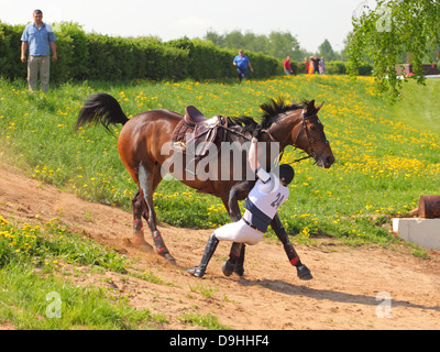 Unfall auf dem Sprung - Konkurrent fallen von ihrem Pferd in die Langlauf-event Stockfoto