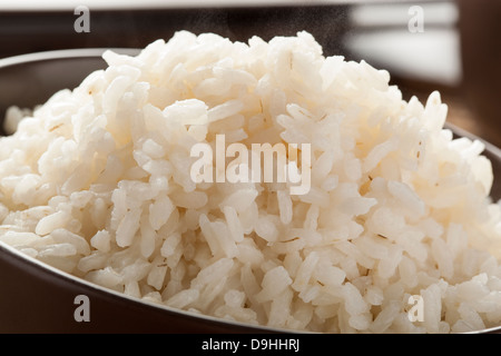 Schüssel mit Bio weisser Reis mit Stäbchen Stockfoto