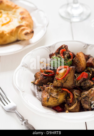 Georgische Küche: Ojakhuri - Schweinefleisch mit Kartoffeln und Gewürzen auf einem weißen Teller. Stockfoto