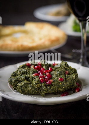 Georgische Küche: Pkhali - traditionelles Gericht aus fein gehackten Spinat serviert mit Granatapfelkernen vorbereitet. Stockfoto