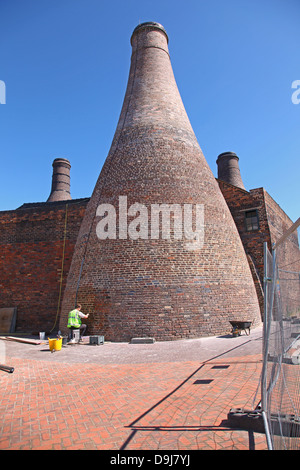 Eine Arbeitskraft, die Reparatur mit dem Hinweis der Flaschenöfen in Gladstone Pottery Museum Longton Stoke Staffordshire England UK Stockfoto