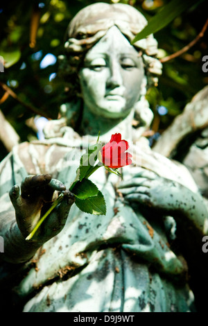 Statue mit einer Rose auf dem waschechter Friedhof in Hamburg, Statue mit einer Rose auf dem Dorffriedhof Ohls in Hamburg Stockfoto