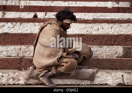 Bettler sitzt auf den Ghats, Varanasi, Benares, Uttar Pradesh, Indien Stockfoto