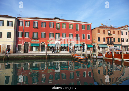 Die bunten alten Gebäude und die Spiegelungen der Boote vertäut am Kanal an Murano Insel Venedig Italien Stockfoto