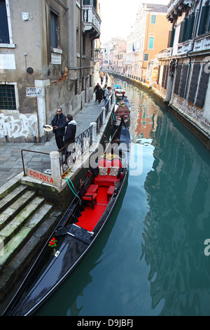 Gondeln und Gondolieri auf einer kleinen Nebenstraße Canal mit bunten Altbauten und hölzernen Liegeplatz Beiträge Venedig im winter Stockfoto