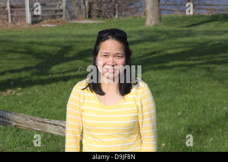 Im mittleren Alter, asiatische Frau in einem kleinen Park auf der Suche Stockfoto