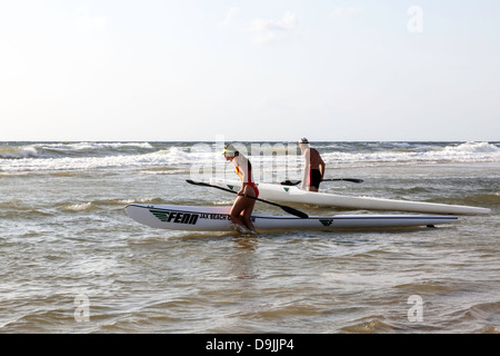 Junger Mann und Frau im Wettbewerb in der 4. jährlichen JAX Strand paddeln Challenge. Stockfoto