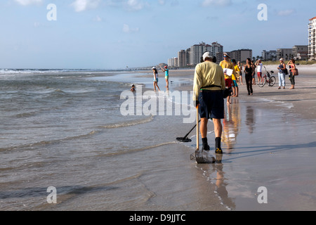 Schatzsucher Scannen Strand mit Metall-Detektor und Sammlung Korb auf der Suche nach verlorenen Schmuck und Münzen. Stockfoto