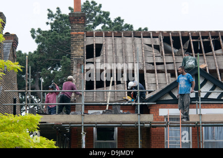 Dachdecker Streifen alte Dach Schiefer auf ein Haus vor dem Austausch mit einem neuen Dach. Stockfoto