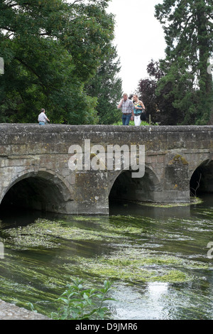 Menschen, die zu Fuß über die alte Steinbrücke mit Fluss unter Stockfoto