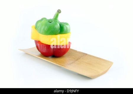 Schneiden Sie die drei Farbe der Paprika in arrangiert vertikal auf Bambus-Schale. Stockfoto