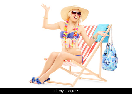 Junge glücklich Frau mit einem Hut posiert auf einem Liegestuhl Stockfoto