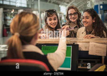 Frau und zwei Mädchen im Teenageralter am Flughafen check-in Bereich Stockfoto