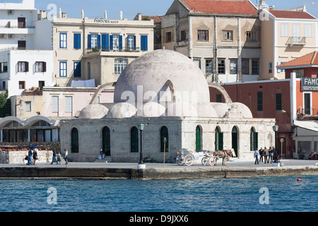 Janitscharen-Moschee (unter mehreren Namen) auf der Hafenpromenade in Chania auf Kreta mit Pferdegespann warten auf Touristen Stockfoto