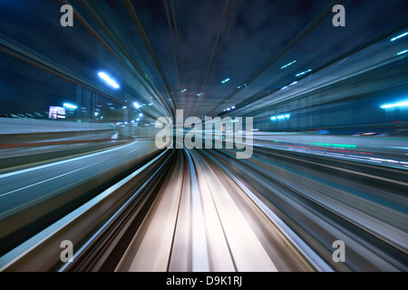 Bewegungsunschärfe für eine Stadt und einen Tunnel von innen eine bewegende Einschienenbahn in Tokio. Stockfoto