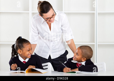 Volksschullehrer im Gespräch mit Schülern im Klassenzimmer Stockfoto