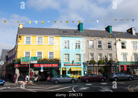 Bunte Geschäfte und Gebäude entlang der Hauptstraße im Zentrum von Kenmare in der Republik Irland. Stockfoto