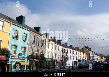 Bunte Geschäfte und Gebäude entlang der Hauptstraße im Zentrum von Kenmare in der Republik Irland. Stockfoto