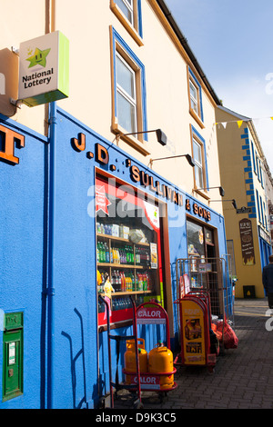 Bunte Geschäfte und Gebäude entlang der Hauptstraße im Zentrum von Kenmare in der Republik Irland. Stockfoto