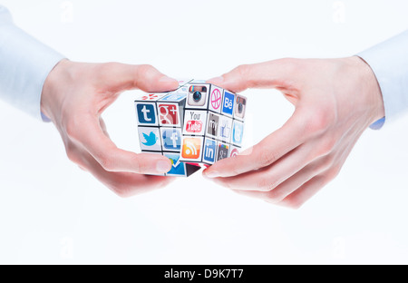 Eine Hand hält Rubiks Cube mit Logos von bekannten social-Media-Marken. Stockfoto