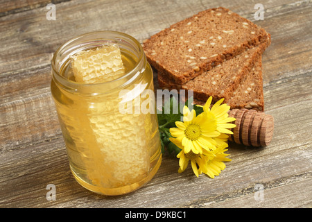 Kämmen Sie Honig mit Vollkornbrot und Blume, Wabenhonig mit Vollkornbrot und Blume Stockfoto