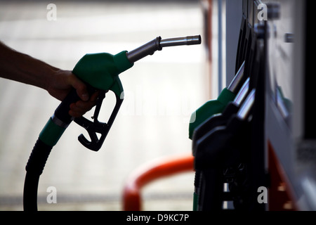 Detail der einen Hand hält eine Kraftstoffpumpe an einer station Stockfoto