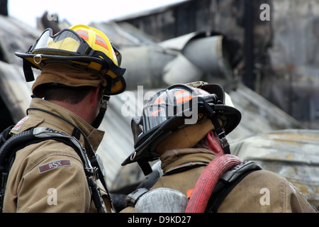 Zwei Feuerwehrleute vor einem eingestürzten Gebäude von einem Feuer Stockfoto