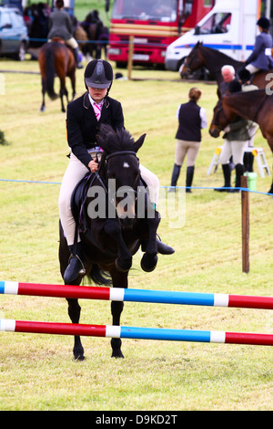 Junges Mädchen Pony bei lokalen Horse Show jumping Stockfoto