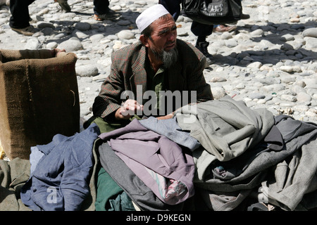 Afghani Verkäufer Verkauf von Kleidung, grenzüberschreitenden Markt in der Nähe von Ishkashim an der Grenze zwischen Tadschikistan und Afghanistan Stockfoto