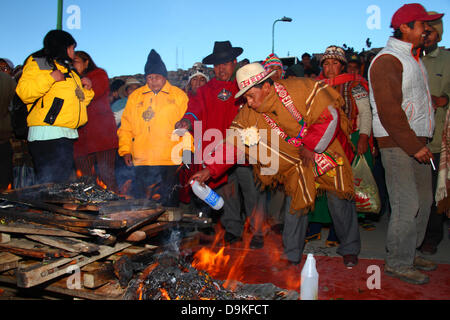 LA PAZ, Bolivien, 21. Juni. Eine männliche Aymara Amauta oder geistiger Führer besprengt Opfergabe von Alkohol auf einem Feuer während eines Ereignisses, Aymara Silvester oder Willka Kuti (auch der Winter-Sonnenwende) zu feiern. Sunrise markiert den Beginn des neuen Jahres (5521 in der Aymara-Kalender). Bildnachweis: James Brunker / Alamy Live News Stockfoto