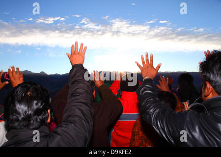 LA PAZ, Bolivien, 21. Juni. Bolivianer halten ihre Hände, die Wärme und Energie der aufgehenden Sonne bei einer Veranstaltung feiern Neujahr Aymara oder Willka Kuti (auch der Winter-Sonnenwende) erhalten. Sunrise markiert den Beginn des neuen Jahres (5521 im Aymara Kalender, Willka Kuti bedeutet Rückkehr der Sonne). In der Ferne sind die Berge der Cordillera Real. Bildnachweis: James Brunker / Alamy Live News Stockfoto