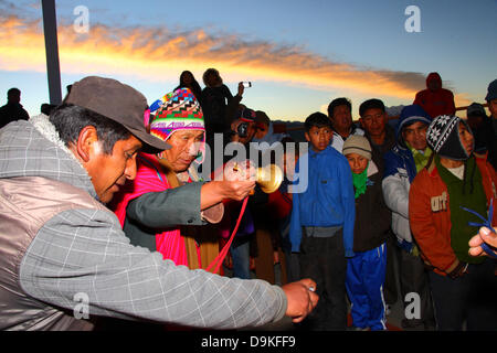 LA PAZ, BOLIVIEN, 21. Juni. Ein männlicher Aymara amauta oder spiritueller Führer (mit einem typischen Wollmütze mit Ohrenklappen genannt Chullo/chullu) läutet eine Glocke, während er während einer Veranstaltung zu den Berggöttern betet, um Aymara Neujahr oder Willka Kuti (auch die Wintersonnenwende) zu feiern. Der Sonnenaufgang ist der Beginn des neuen Jahres (5521 im Aymara-Kalender). Quelle: James Brunker / Alamy Live News Stockfoto