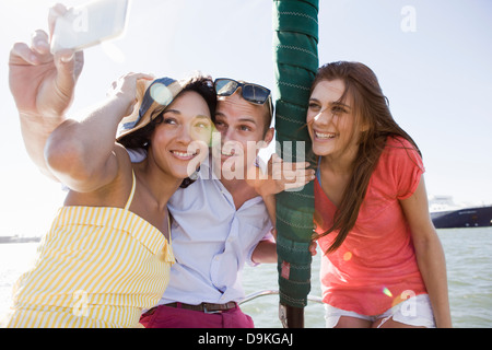 Drei junge Freunde auf Yacht selbst zu fotografieren Stockfoto