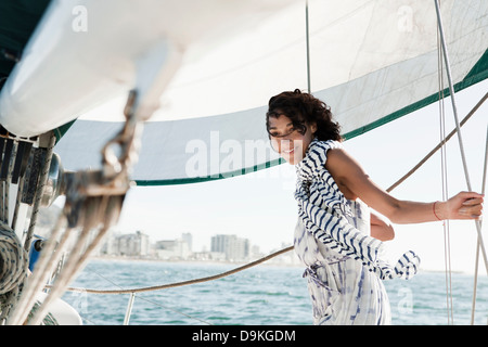 Junge Frau auf Yacht trägt gestreiften Schal Stockfoto