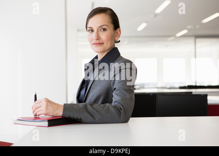 Geschäftsfrau am Schreibtisch mit Stift