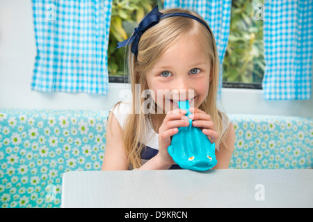 Porträt des jungen Mädchens Sprengung Ballon im Wohnwagen Stockfoto