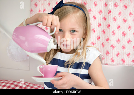 Porträt des jungen Mädchens Gießen Tee in Wohnwagen Stockfoto