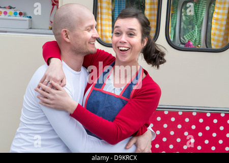 Mitte erwachsenes paar umarmt außerhalb Wohnwagen Stockfoto