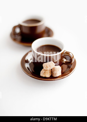Frischer Kaffee in Tassen mit braunem Zucker Klumpen Stockfoto