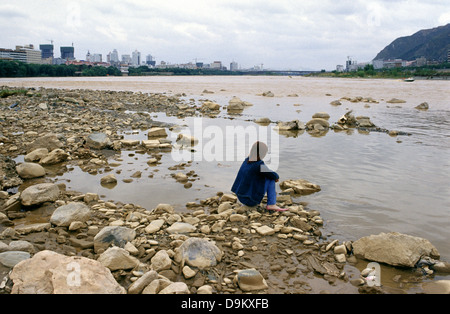 Einsame junge chinesische Frau Standortwahl am Ufer des Huang He Yellow River fließt durch die Stadt Lanzhou Gansu Province China Stockfoto