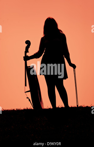 Silhouette eines Mädchens mit einem Cello und Bogen. Stockfoto