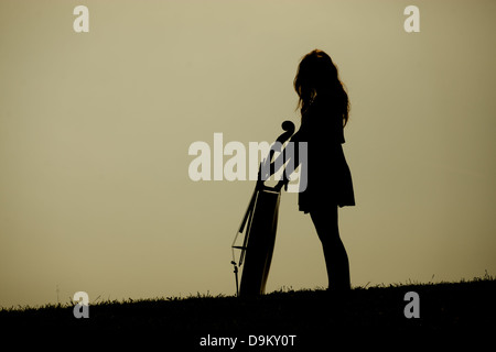 Silhouette eines Mädchens mit einem Cello und Bogen. Stockfoto
