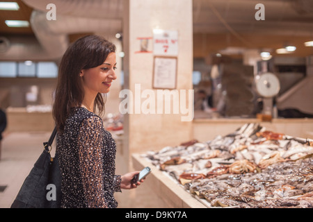 Frau betrachten Frischfisch im Markt Stockfoto