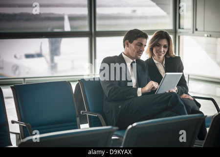 Geschäftsleute, die mit digital-Tablette in Flughafen-Abflug-lounge Stockfoto