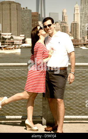 Junge Frau küssen ihr Verlobter mit Manhattan Skyline im Hintergrund Stockfoto