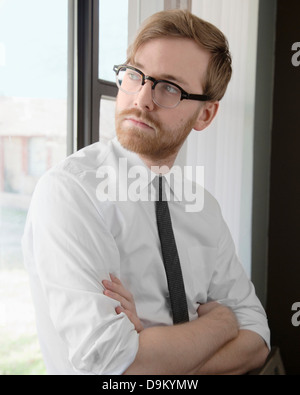 Junger Mann mit Brille und Krawatte wegschauen Stockfoto