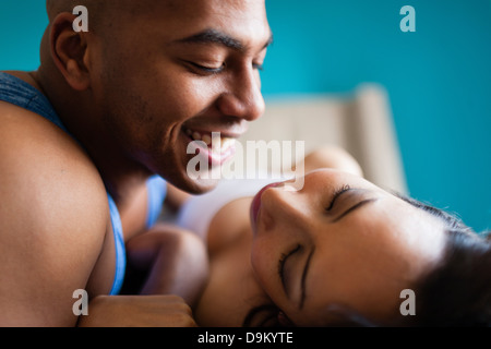 Mitte erwachsenes paar entspannende auf Bett Stockfoto